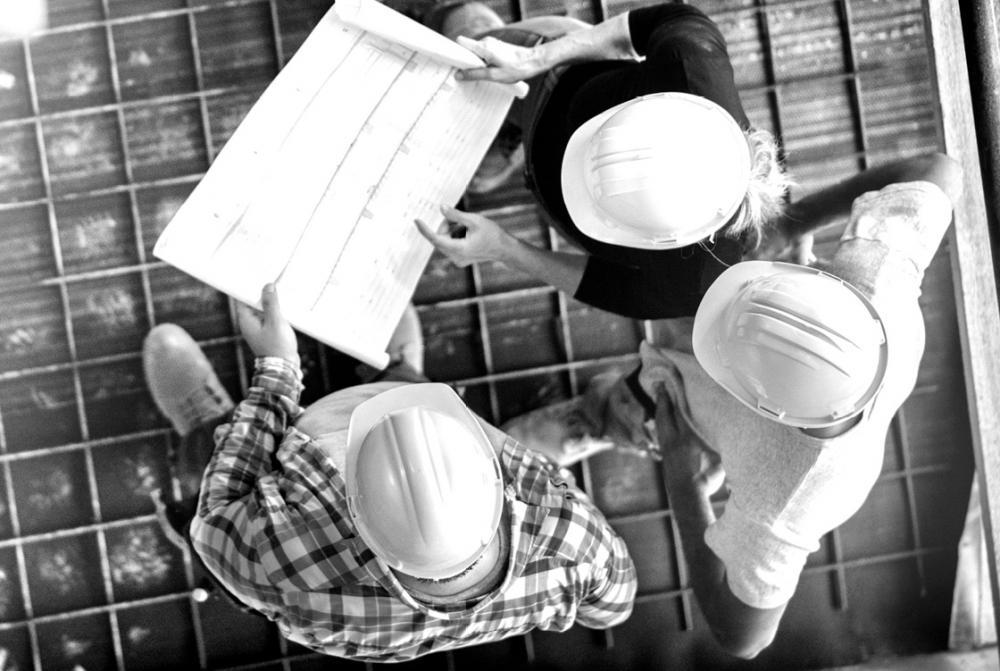 Building contractors on site in hard hats - DUAL Oliva